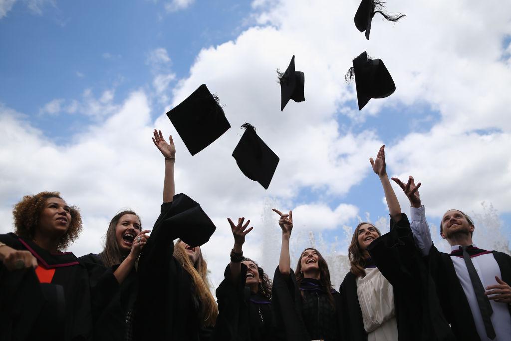 Alt: College graduates throwing their caps in the air